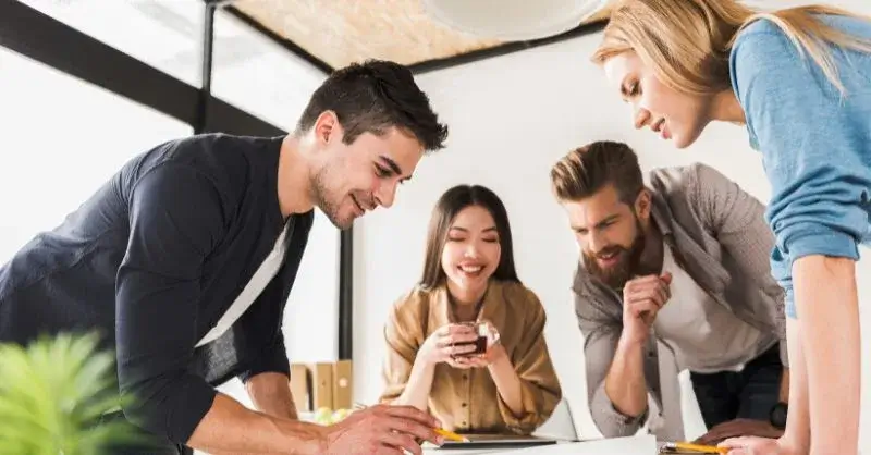 Four professionals standing and in discussion around a table