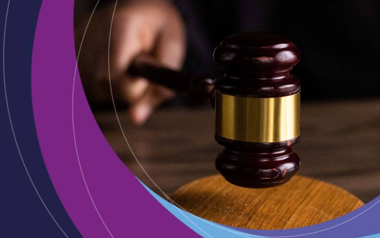 A hand holding a gavel